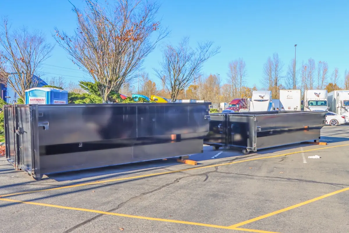 Professional dumpster rental service with roll-off container on residential driveway in Greenfield